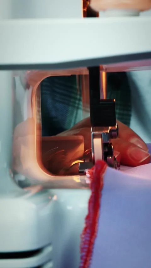 Working overlock machine sewing  edge of fabric, close up. Vertical video Stock Footage 318168257