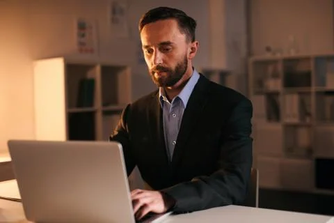 Working overtime in the office space alone at the table. Stock Photos