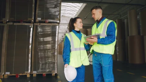 Working partners are talking in the warehouse of a cardboard factory. Teamwork. Stock Footage 220854708