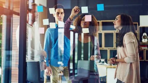 Working on a plan to boost their success. a group of young designers Stock Photos