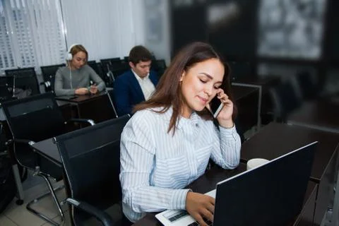 Working process, female office worker talk by telephone with colleagues 库存照片