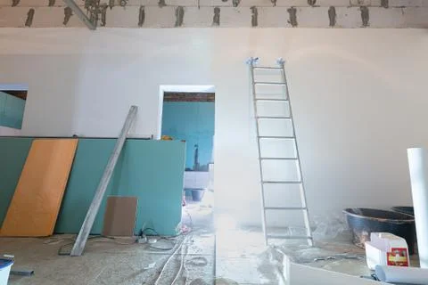 Working process of installing plasterboard or drywall for making gypsum walls in Stock Photos