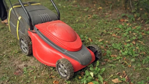 Working process of lawn mower outdoors. Woman cutting garden lawn Stock Footage 119147364