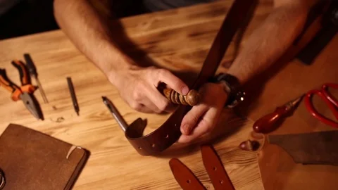 Working process of the leather belt in the leather workshop. Man holding Stock Footage 80659327