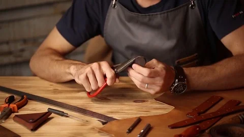 Working process of the leather belt in the leather workshop. Man holding Stock Footage 80659386