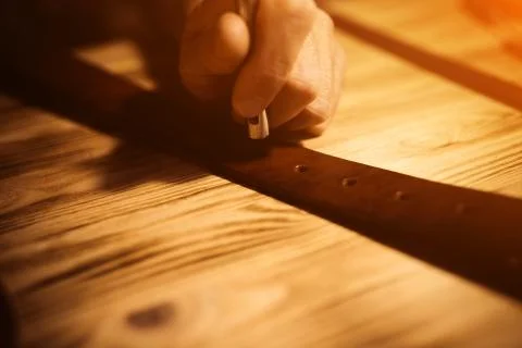 Working process of the leather belt in the leather workshop. Man holding Stock Photos