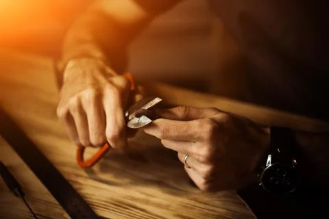Working process of the leather belt in the leather workshop. Man holding Stock Photos