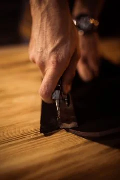 Working process of the leather belt in the leather workshop. Man holding Stock Photos