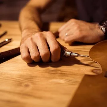 Working process of the leather belt in the leather workshop. Man holding Stock Photos