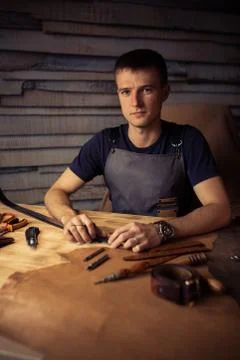 Working process of the leather belt in the leather workshop. Man holding Stock Photos