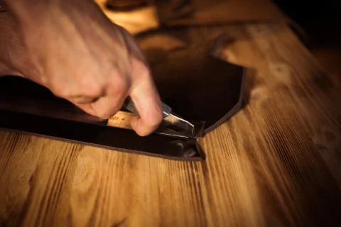 Working process of the leather belt in the leather workshop. Man holding Stock Photos
