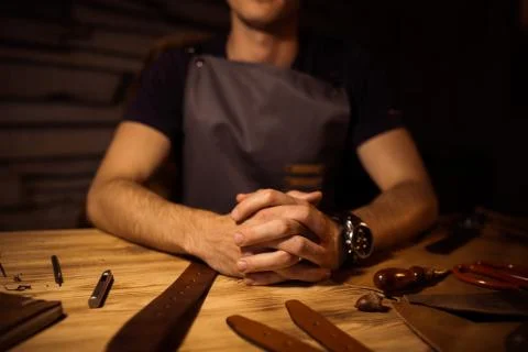 Working process of the leather belt in the leather workshop. Man holding hands Stock Photos