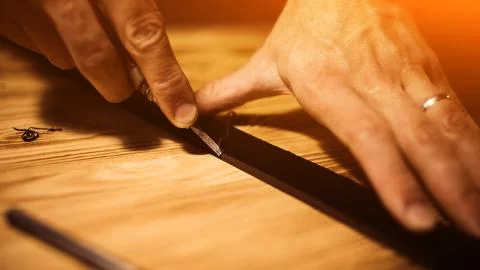Working process of the leather belt in the leather workshop. Man holding tool Stock Photos