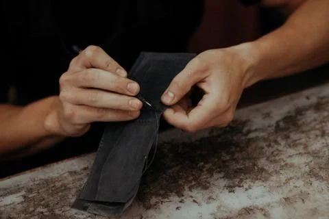 Working process of the leather wallet in the workshop. Man holding leather craft Stock Photos
