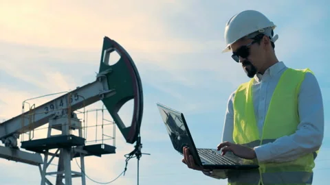 Working process of a male worker holding a laptop next to a functioning gas Stock Footage 98174690