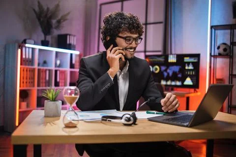 Working process at office of young confident guy in suit at evening time. Foto stock