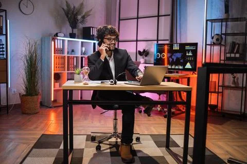 Working process at office of young confident guy in suit at evening time. 写真素材