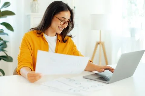 Working process. Positive arabian or indian brunette woman, wearing eyeglasses Stock Photos