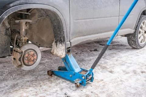 The working process of removing the wheels from the car on the street in the Stock Photos