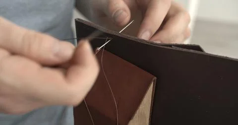 Working process of stitching a brown leather wallet by needle in the leather Stock Photos