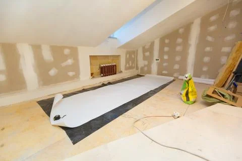 Working process of wallpapering on the drywall in small room apartment is under Stock Photos