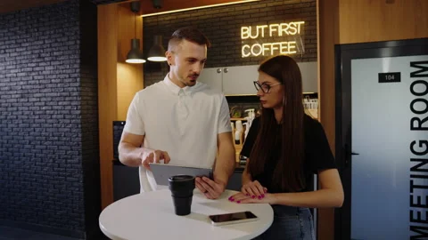 Working on a project. Two colleagues during a coffee break in the office Stock Footage 219805690