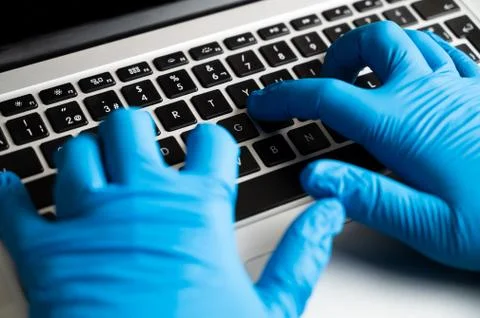 Working with protective gloves on computer Stock Photos