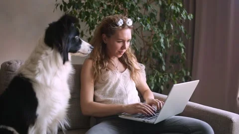 Working Remotely. CRANE SHOOT Young Woman freelancer and her dog working from Stock Footage 130382556