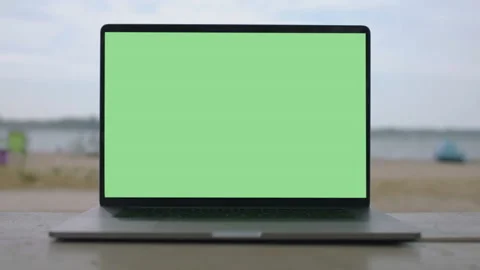 Working remotely. Green screen laptop computer sitting on bench near the beach. Stock Footage 136110765
