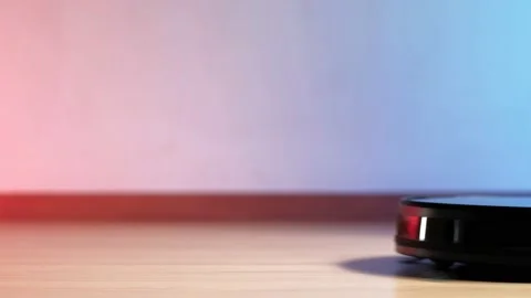 Working robot vacuum cleaner. red and blue lights on the wall. no furniture. Stock Footage 135952993
