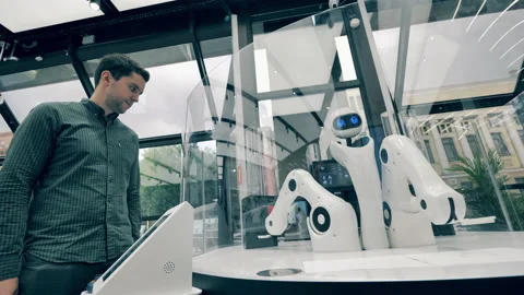 Working robot waiter and a client. Futuristic robot arm works serving man. Video stock 140635504