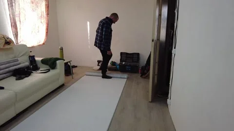 Working in a room with white roll on the floor at home in the morning Stock Footage 332563624