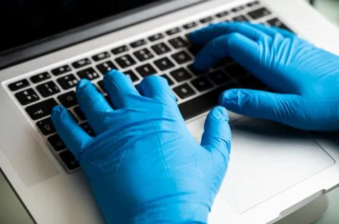 Working safe with protective gloves on computer. Coronavirus prevention. Stock Photos