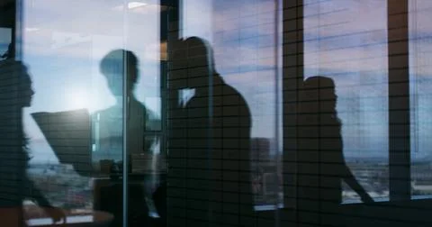 Working on a sensitive project. Silhouette shot of two businesspeople having a Stock Photos