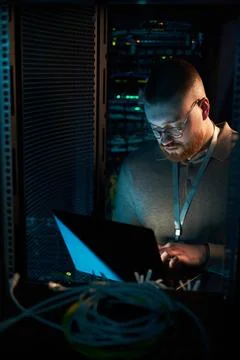 Working in Server Room Surrounded by Network Equipment Stock Photos