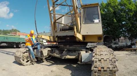 Working sitting on crawler cranes and eating potato chips. 스톡 동영상 52251482