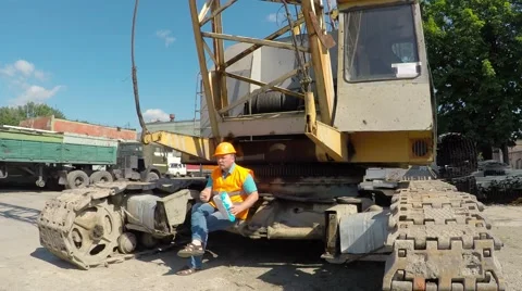 Working sitting on crawler cranes and eating potato chips. Video stock 52251619