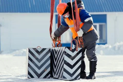 Working slinger hooks load with hook with slings. Work on unloading cargo Foto stock