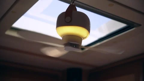 A working small fan with lighting is mounted on the ceiling of a mobile home Stockbeeldmateriaal 312873510