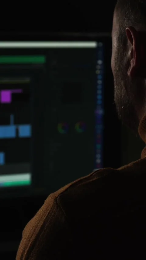 Working on software development in a dark room with bright computer screens at Stock Footage 323620611