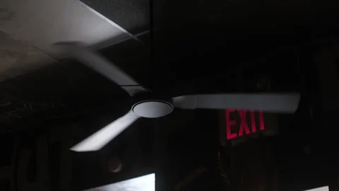 Working spinning ceiling fan with exit sign in the background Stock Footage 335304790