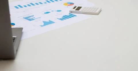 Working table with notebook, chart paper and calculator on white table. Stock Photos