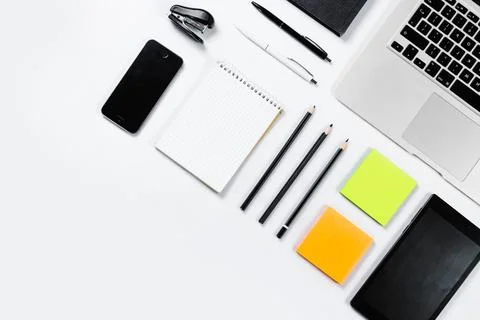 Working table top view, flat lay. Business items on a white table, laptop, cl Stock Photos