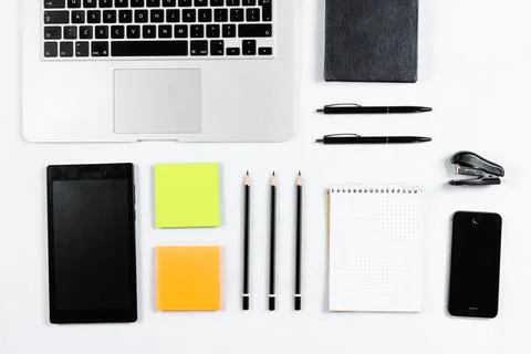 Working table top view, flat lay. Business items on a white table, laptop, cl Stock Photos