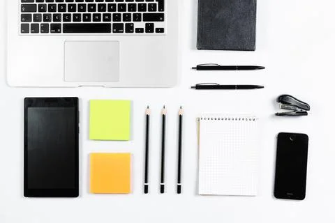 Working table top view, flat lay. Business items on a white table, laptop, cl Stock Photos