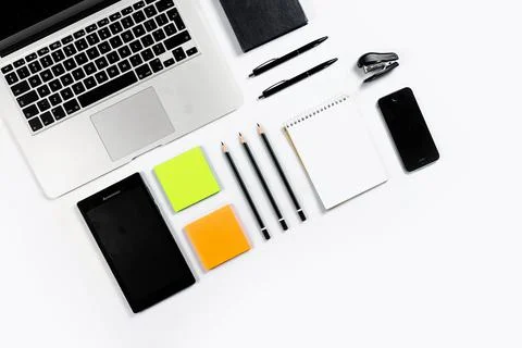 Working table top view, flat lay. Business items on a white table, laptop, cl Stock Photos