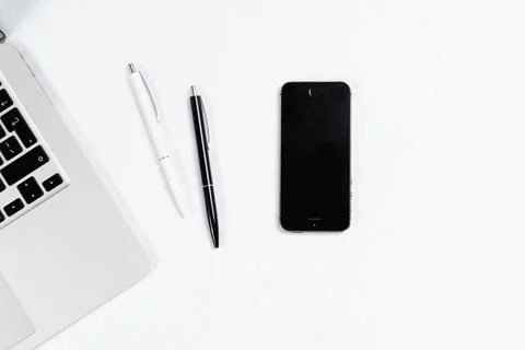 Working table top view, flat lay. Business items on a white table, laptop, cl Stock Photos