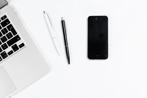 Working table top view, flat lay. Business items on a white table, laptop, cl Stock Photos