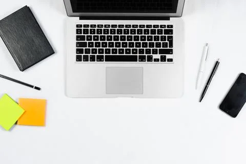 Working table top view, flat lay. Business items on a white table, laptop, cl Stock Photos