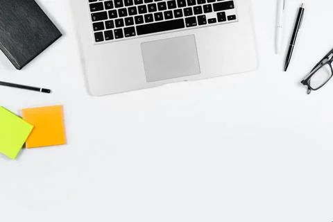 Working table top view, flat lay. Business items on a white table, laptop, cl Stock Photos